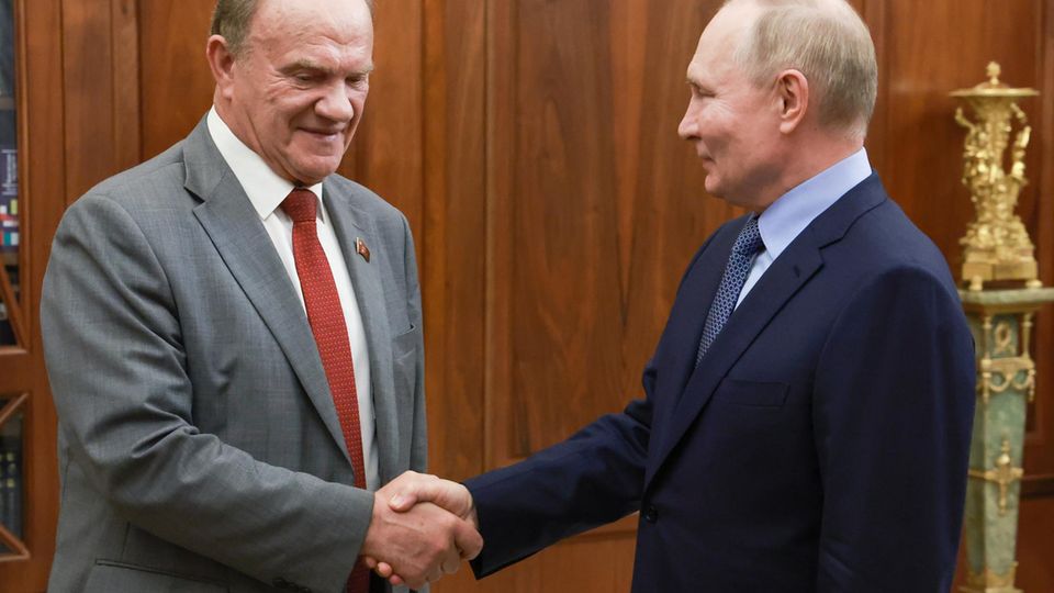 Russlands Präsident Putin und der Vorsitzende der Kommunistischen Partei Russlands, Sjuganow, geben sich die Hand