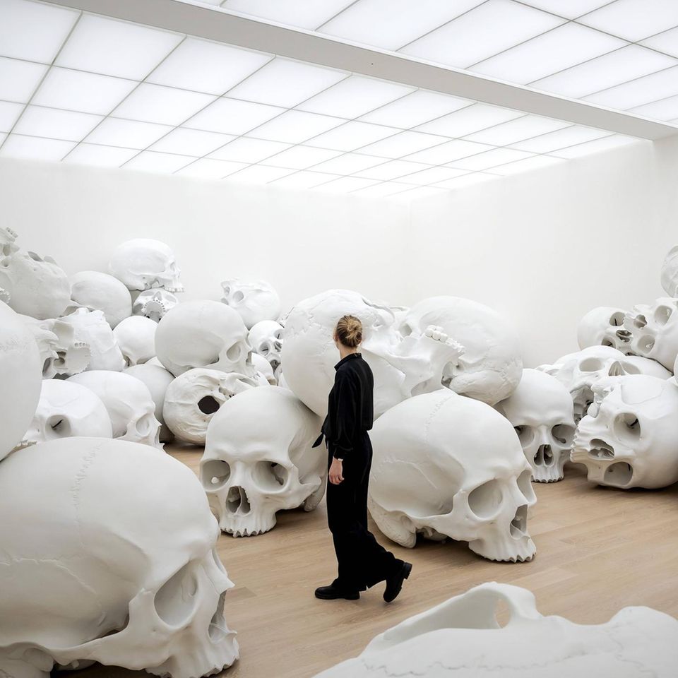 Riesige Skulpturen von Totenschädeln in einem hellen Raum