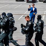 Ein Abgeordneter der AfD steht auf dem Parkplatz der Grugahalle und filmt mit einem Smartphone die Gegendemonstration und Polizisten