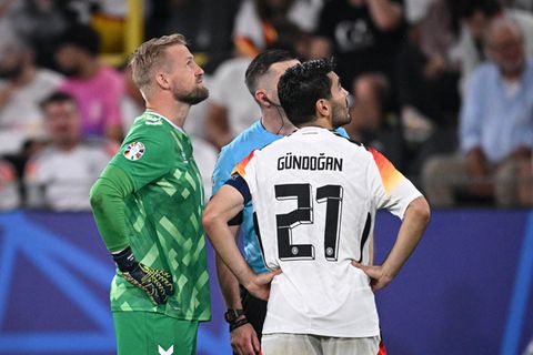 Schiedsrichter Michael Oliver informiert die beiden Kapitäne Ilkay Gündogan und Kasper Schmeichel des EM-Spiels über die Geschehnisse
