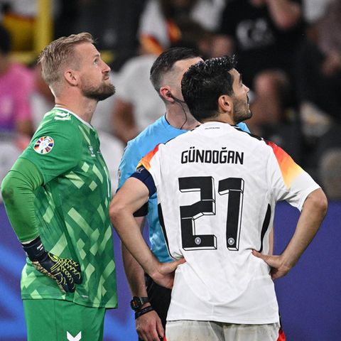 Schiedsrichter Michael Oliver informiert die beiden Kapitäne Ilkay Gündogan und Kasper Schmeichel des EM-Spiels über die Geschehnisse