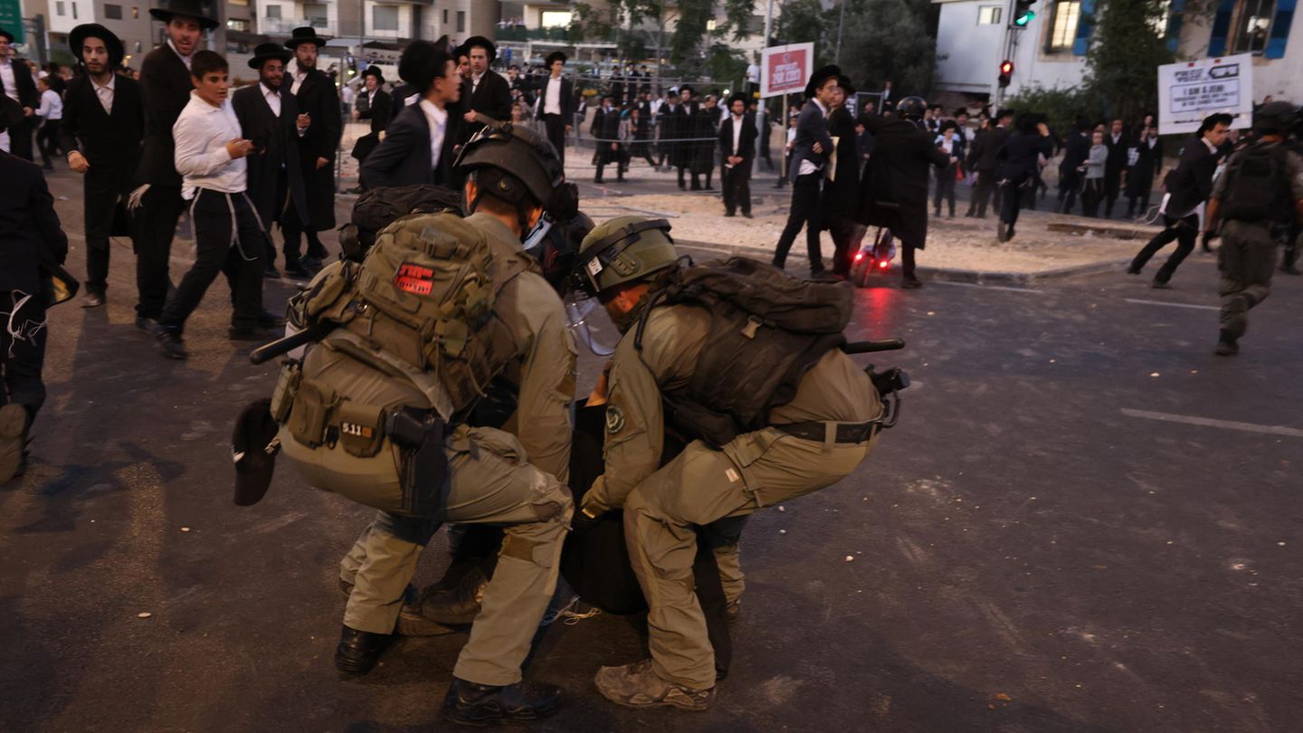 Sicherheitskräfte versuchen, eine Sitzblockade zu beenden. Viele Israelis empfinden es als ungerecht, dass Ultraorthodoxe vom Dienst an der Waffe und gefährlichen Kampfeinsätzen ausgenommen sind. Es gibt allerdings auch ultraorthodoxe Männer, die freiwillig dienen