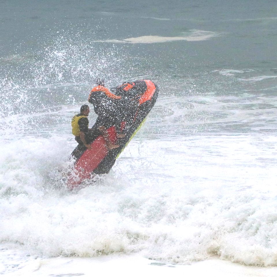 Rio de Janeiro, Brasilien. Rettungsschwimmer kämpfen sich auf einem Jetski durch die starke Brandung am Strand der "Cidade Maravilhosa", der wunderbaren Stadt, wie Rio auch genannt wird. Die brasilianische Marine hat eine Warnung vor bis zu drei Meter hohen Wellen für die Küste herausgegeben