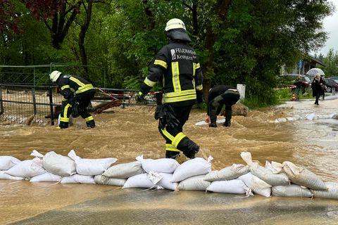 Einsatzkräfte der Feuerwehr versuchen Fluten mit Sandsäcken aufzuhalten