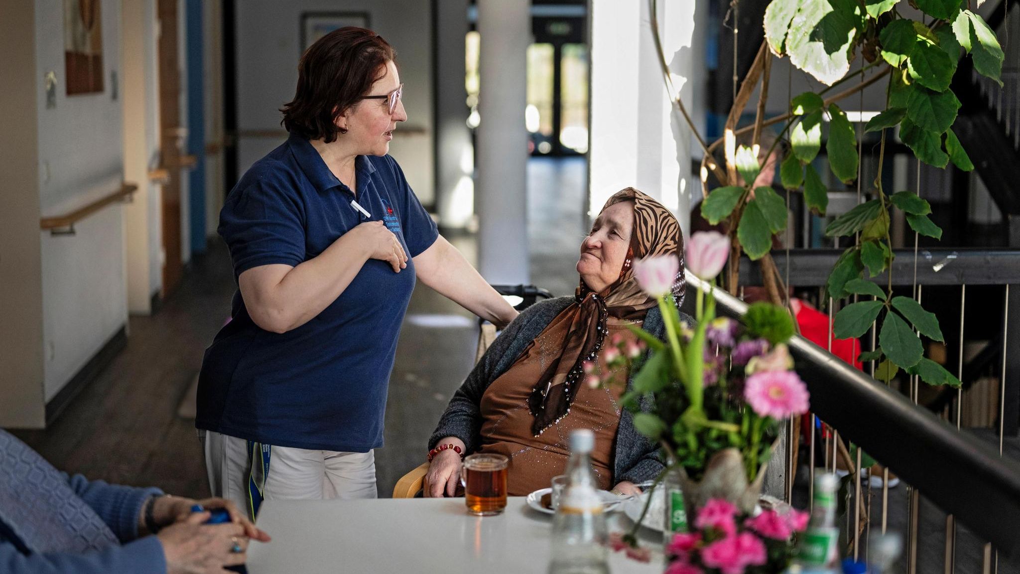 Eine Pflegekraft spricht mit einer alten Frau im Pflegeheim in Duisburg
