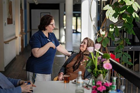Eine Pflegekraft spricht mit einer alten Frau im Pflegeheim in Duisburg