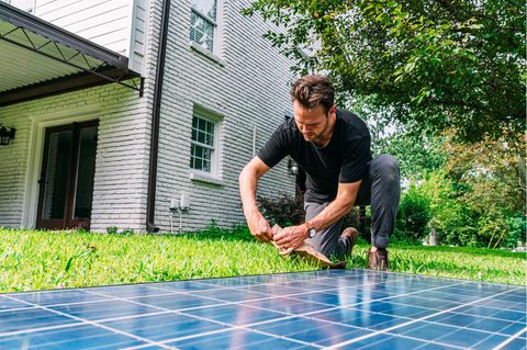 Garten-Solaranlage installieren: Mann montiert ein Solarmodul im Garten.