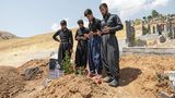 Männliche Verwandte beten an dem Grab eines erschossenen Iraners