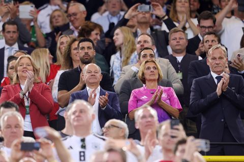 Menschen stehen bei der EM im Stadion auf der Tribüne und klatschen