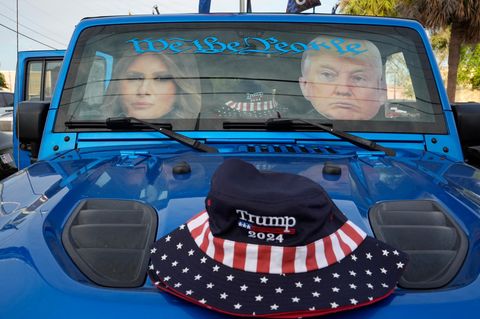 Fotos von Donald Trump und seiner Frau hängen hinter der Frontscheibe eines Jeeps, auf der Motorhaube liegt eine Trump-Mütze