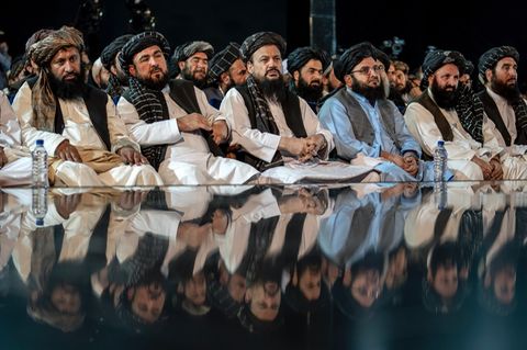 Mehrere Taliban sitzen auf dem Boden.