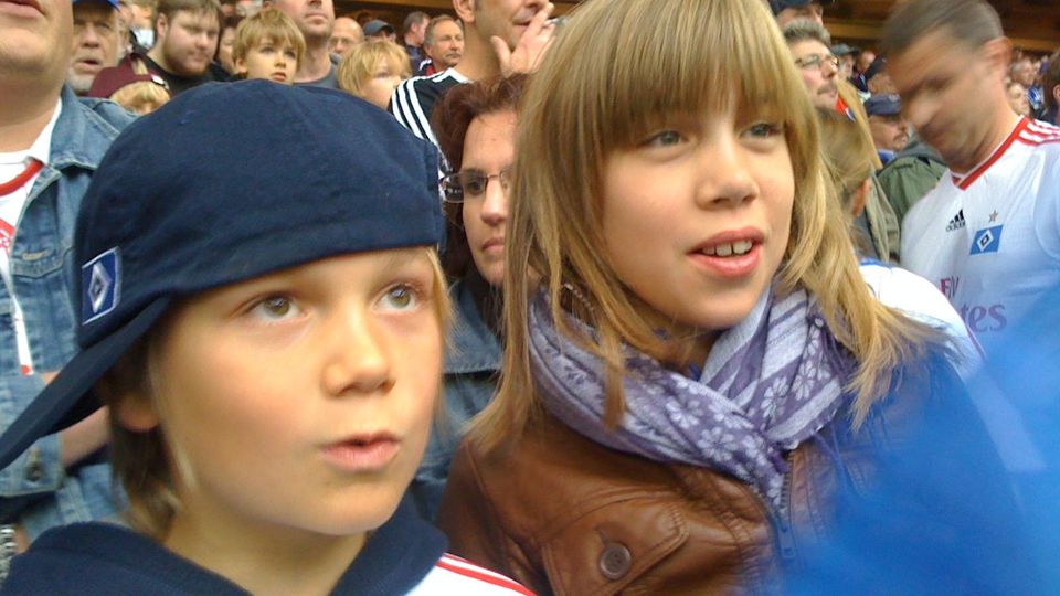 Bruder und Schwester schauen ein Fußballspiel, wie sie es auch heute während der EM tun könnten