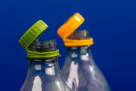 Gelber und grüner angebundener Deckel an Plastikflaschen