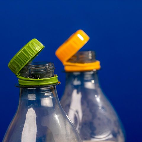 Gelber und grüner angebundener Deckel an Plastikflaschen