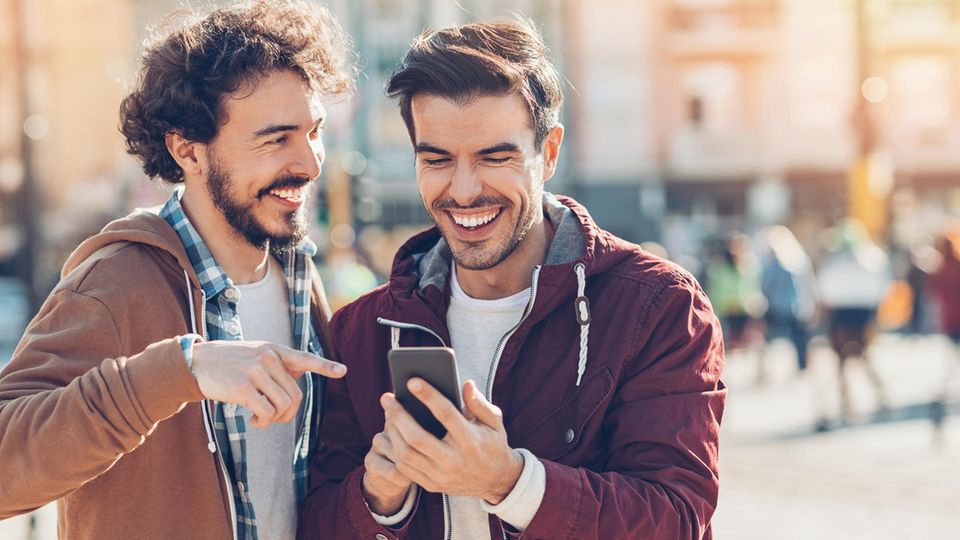 Tarif-Kracher im Telekom-Netz: Zwei Männer lachend mit Handy.