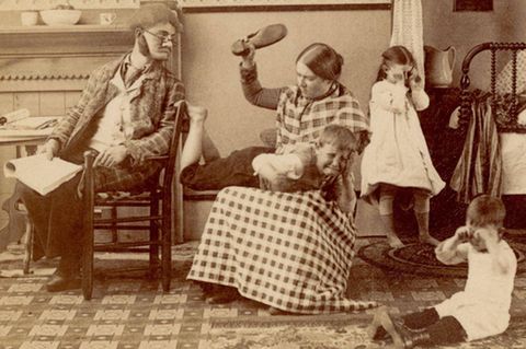 Mutter haut weinenden Sohn mit einem Schuh auf dessen Gesäß