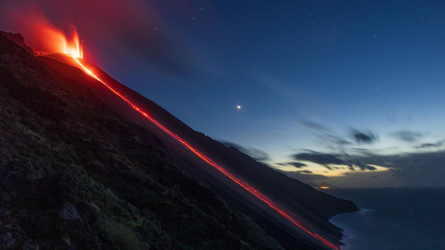 Ein Lavafluss reicht bis zum Meer.