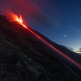 Ein Lavafluss reicht bis zum Meer.