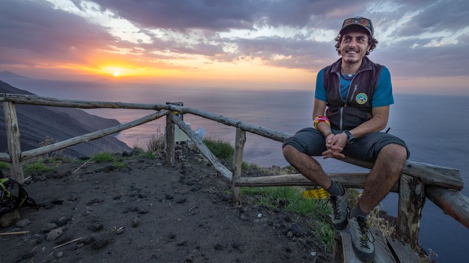 Der Vulkanführer Adriano Di Pietro sitzt auf einem Zaun im Sonnenuntergang auf Stromboli