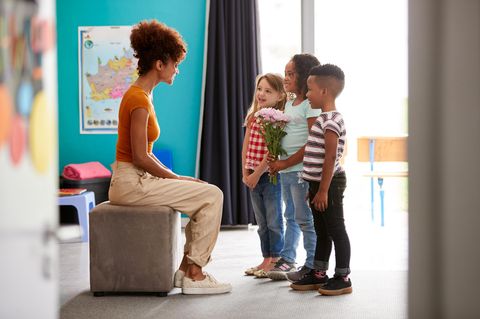 Kinder überreichen einer Lehrerin ein Abschiedsgeschenk