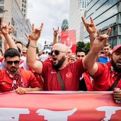 Türkische Fans zeigen beim Fan-Marsch in Berlin den Wolfsgruß