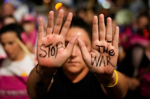 Eine Frau hat auf ihre Handflächen "Stop the War" geschrieben