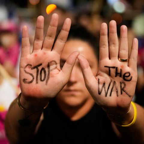 Eine Frau hat auf ihre Handflächen "Stop the War" geschrieben