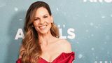 Hillary Swank, eine Frau in einem schicken Kleid, lächelt in die Kamera