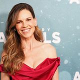 Hillary Swank, eine Frau in einem schicken Kleid, lächelt in die Kamera