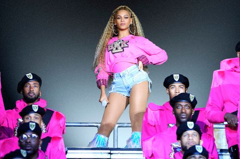 Beyoncé steht auf einer Bühne mit Mikrofon in der Hand