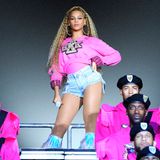 Beyoncé steht auf einer Bühne mit Mikrofon in der Hand