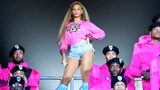 Beyoncé steht auf einer Bühne mit Mikrofon in der Hand