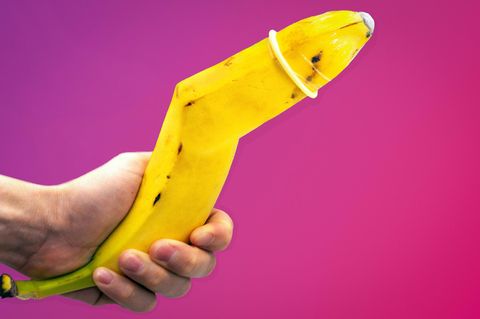 Banane mit Knick und einem Kondom auf der Spitze