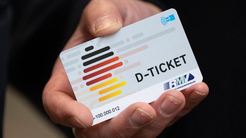 Ein Deutschlandticket in de Hand eines Mannes