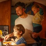 Der Vater steht mit seinen zwei Söhnen in der Küche des Airstreams und bereitet Pizza zu