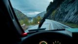Blick durch die Frontscheibe des Autos während einer verregneten Fahrt durch Norwegen