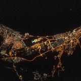 Ein Luftbild zeigt Lichter der Küste des Oman und den Flughafen Mascat