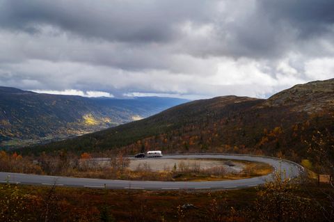 Eine Passstraße in Norwegen in herbstlich verfärbter Landschaft - klein im Bild: Der Airstream