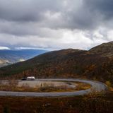 Eine Passstraße in Norwegen in herbstlich verfärbter Landschaft - klein im Bild: Der Airstream