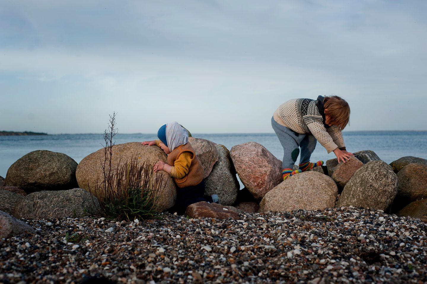 Die beiden Jungs spielen auf einigen großen Steinen am Strand