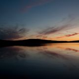 Die untergehende Sonne taucht Himmel und Fjord in schönste Farben