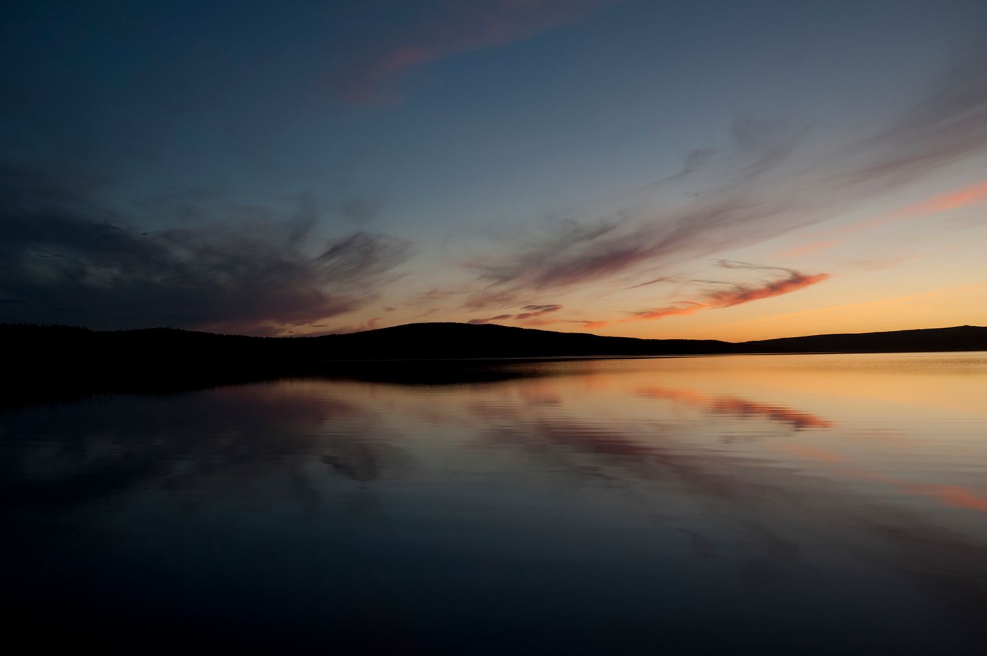Die untergehende Sonne taucht Himmel und Fjord in schönste Farben