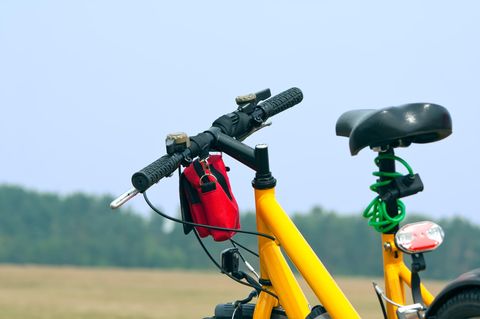 Fahrrad verkehrssicher: Gelbes Damenrad mit Beleuchtung und Klingeln steht in der Natur