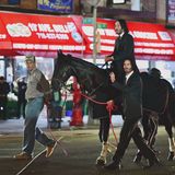 Keanu Reeves und sein Stunt Double auf einem Pferd in den Straßen von Brooklyn. Das Pferd wird von einem Mann geführt.