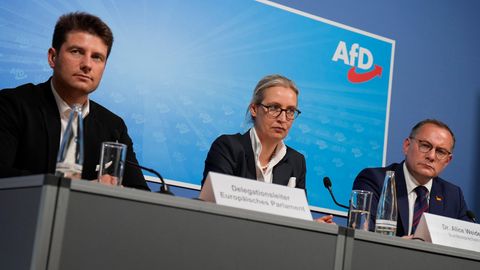 René Aust, Alice Weidel und Tino Chrupalla sitzen bei einer Pressekonferenz vor AfD-Logo
