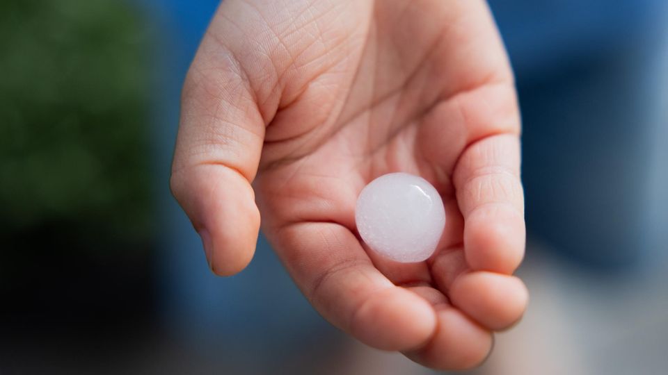Mai 2024: Ein Kind hält ein fast 2 Zentimeter großes Hagelkorn in der Hand