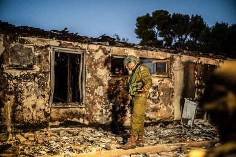 Ein Soldat steht im zerstörten Kibbuz Be’eri in Israel