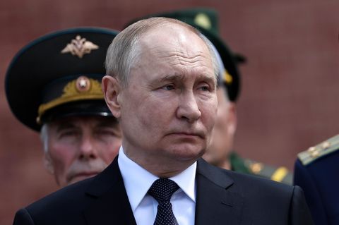 Russlands Präsident Wladimir Putin steht vor Militärs in Gardeuniformen