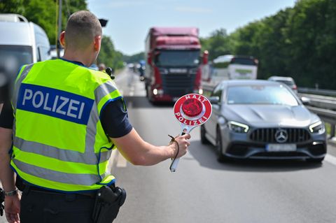 Polizist führt auf der Autobahn Grenzkontrollen durch