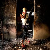 Badelatschen, Baggy Pants und ein Sturmgewehr, das fast so groß ist wie er selbst: ein Gang-Mitglied in Port-au-Prince